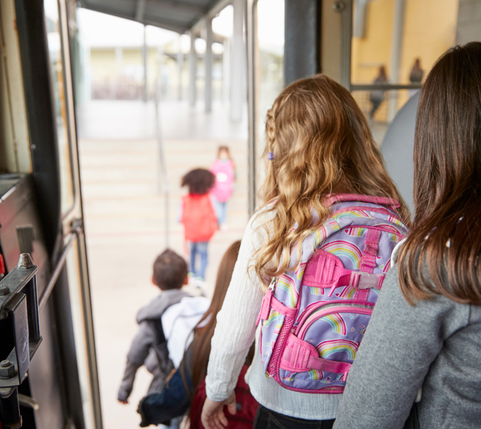 Busbegleiter Kinder steigen aus einem Bus aus. Das Foto ist aus der Sicht eines Busfahrenden
