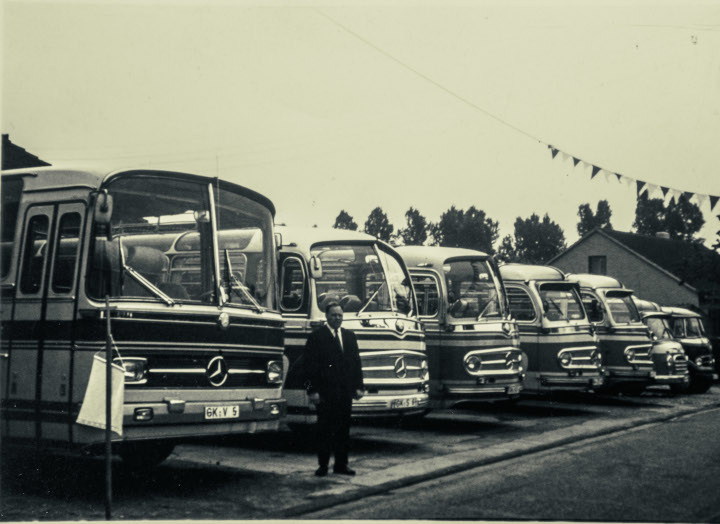 Ende der 60er Jahre Ein Mann steht vor einer Flotte an Bussen zu Personenbeförderung