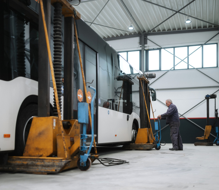 Wartung Ein Werkstattmitarbeiter wechselt einem Bus die Reifen